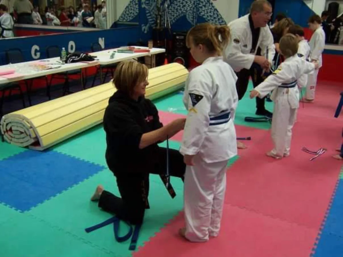 Student receiving a new belt from instructor at Rise Up NJ martial arts in Atco NJ