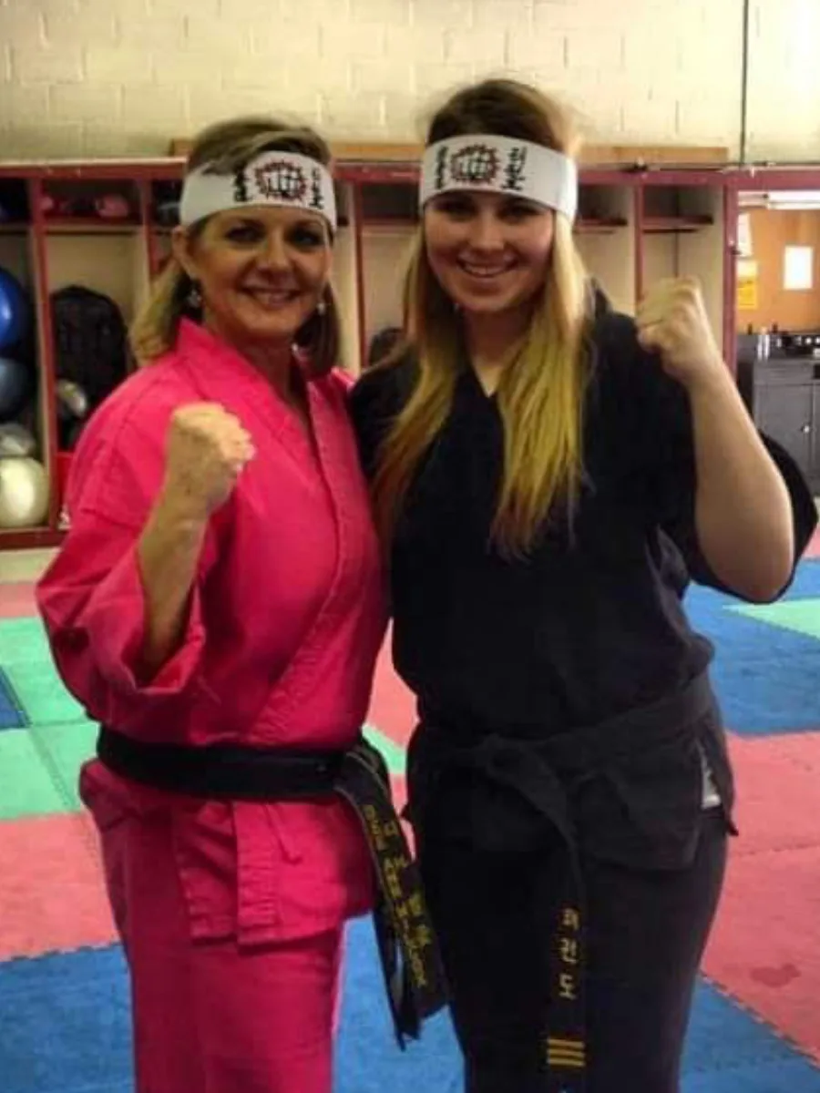 Two adult students with fists raised after a Rise Up NJ training session